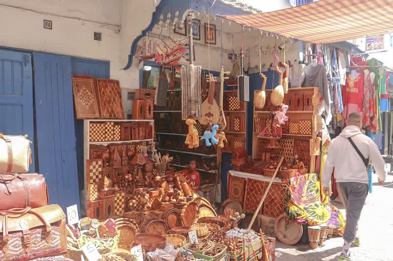 Traditional thuya woodworking in an Essaouira medina atelier, tools and burl wood on the workbench