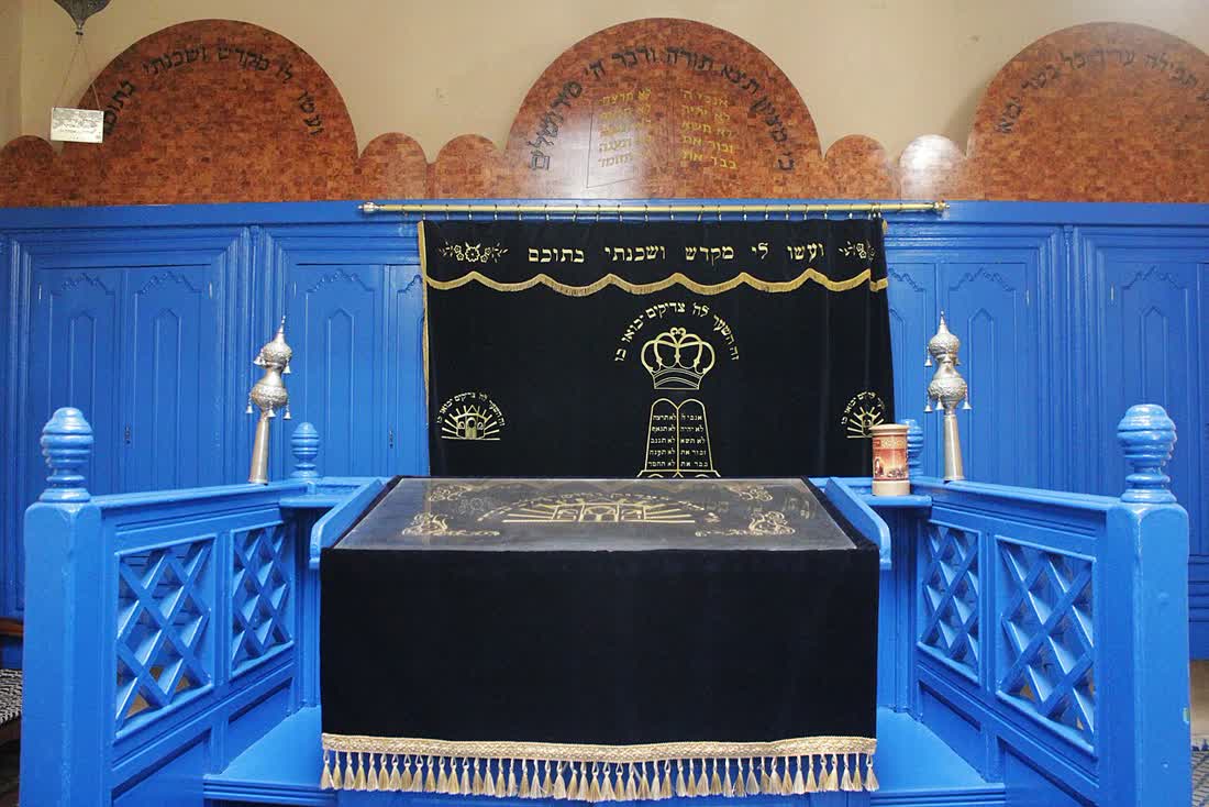 Interior of the Haim Pinto synagogue in Essaouira's mellah, painted blue woodwork and hanging lamps