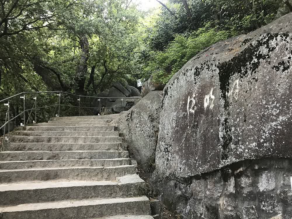 The Literary Path in Senkoji Park, stone monuments along a wooded hillside trail